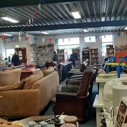 Ruime winkelvloer met zithoeken, boekenkasten, speelgoed en diverse meubels in kringloopwinkel