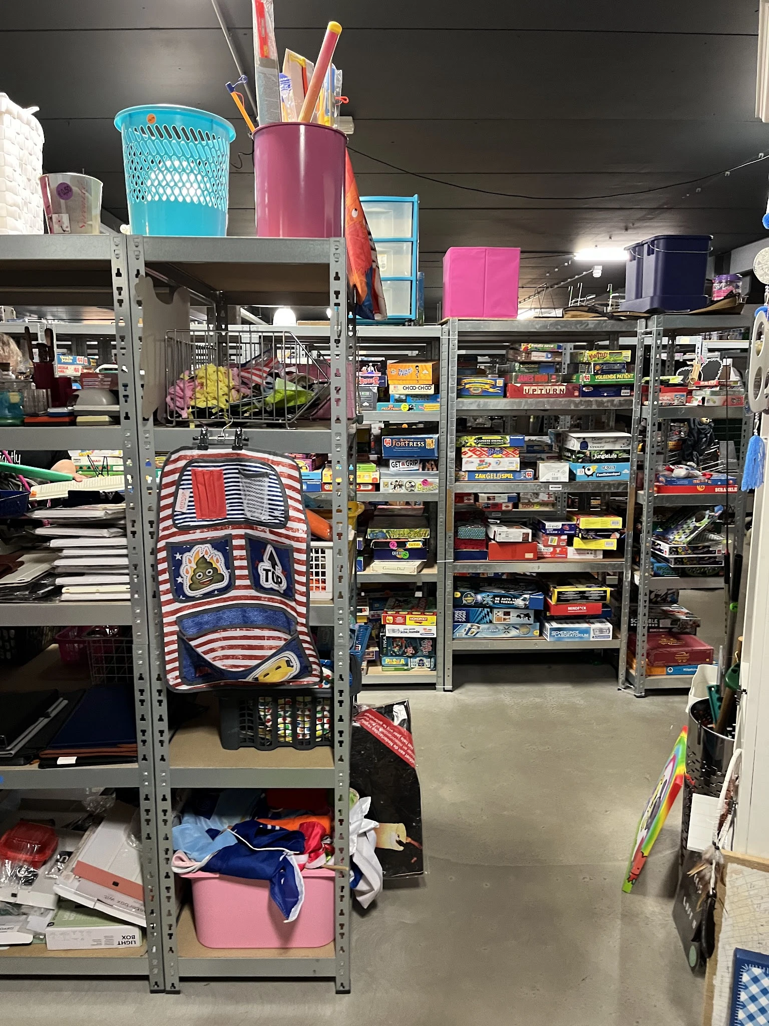 Overzicht van stellingen met diverse tweedehands spullen en dozen in een kringloopwinkel