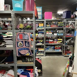 Overzicht van stellingen met diverse tweedehands spullen en dozen in een kringloopwinkel