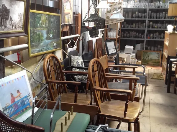 Winkelvloer met houten stoelen, tafels en verschillende meubels en kunstvoorwerpen