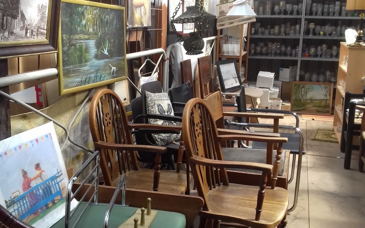 Winkelvloer met houten stoelen, tafels en verschillende meubels en kunstvoorwerpen