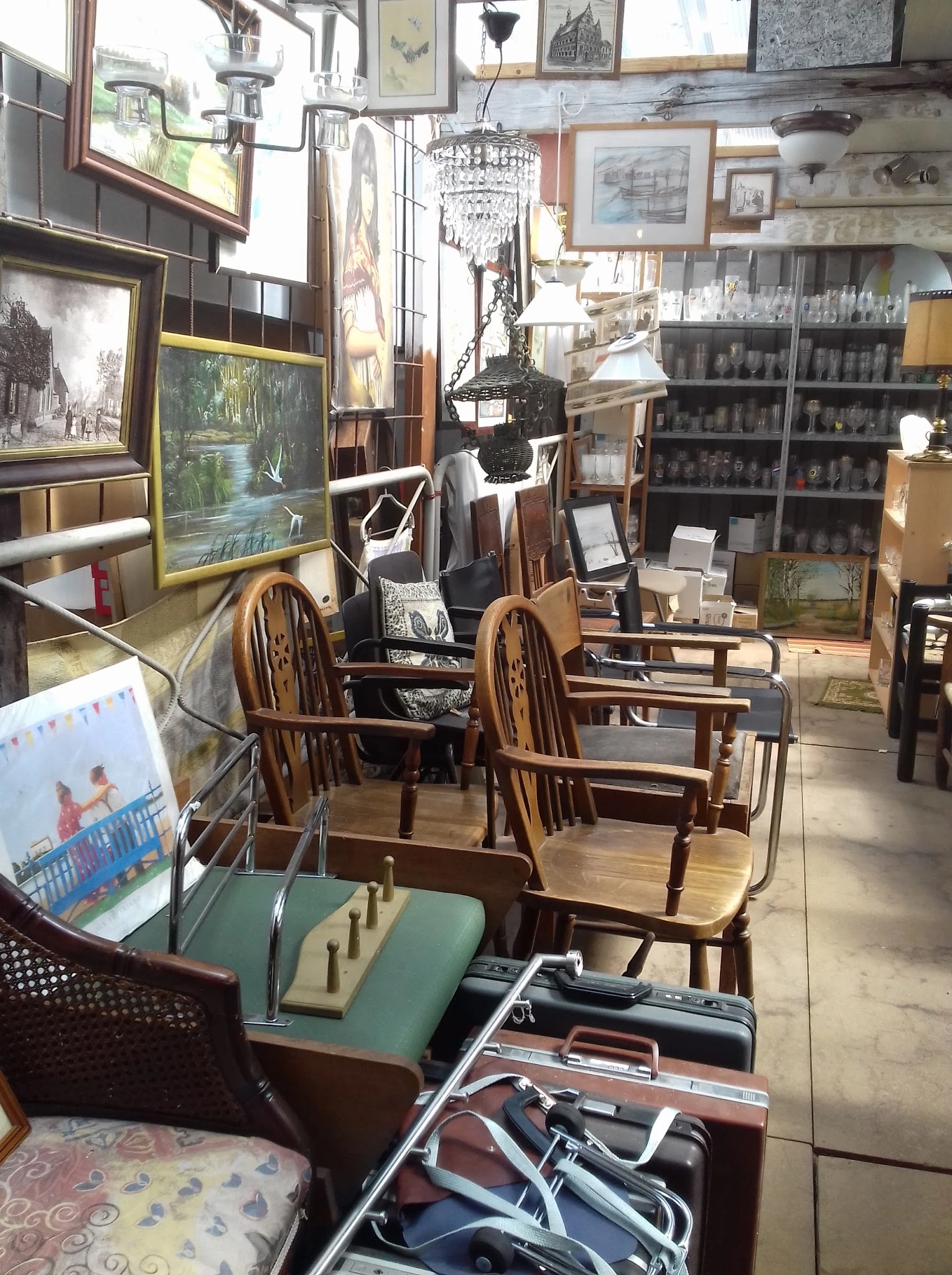 Winkelvloer met houten stoelen, tafels en verschillende meubels en kunstvoorwerpen