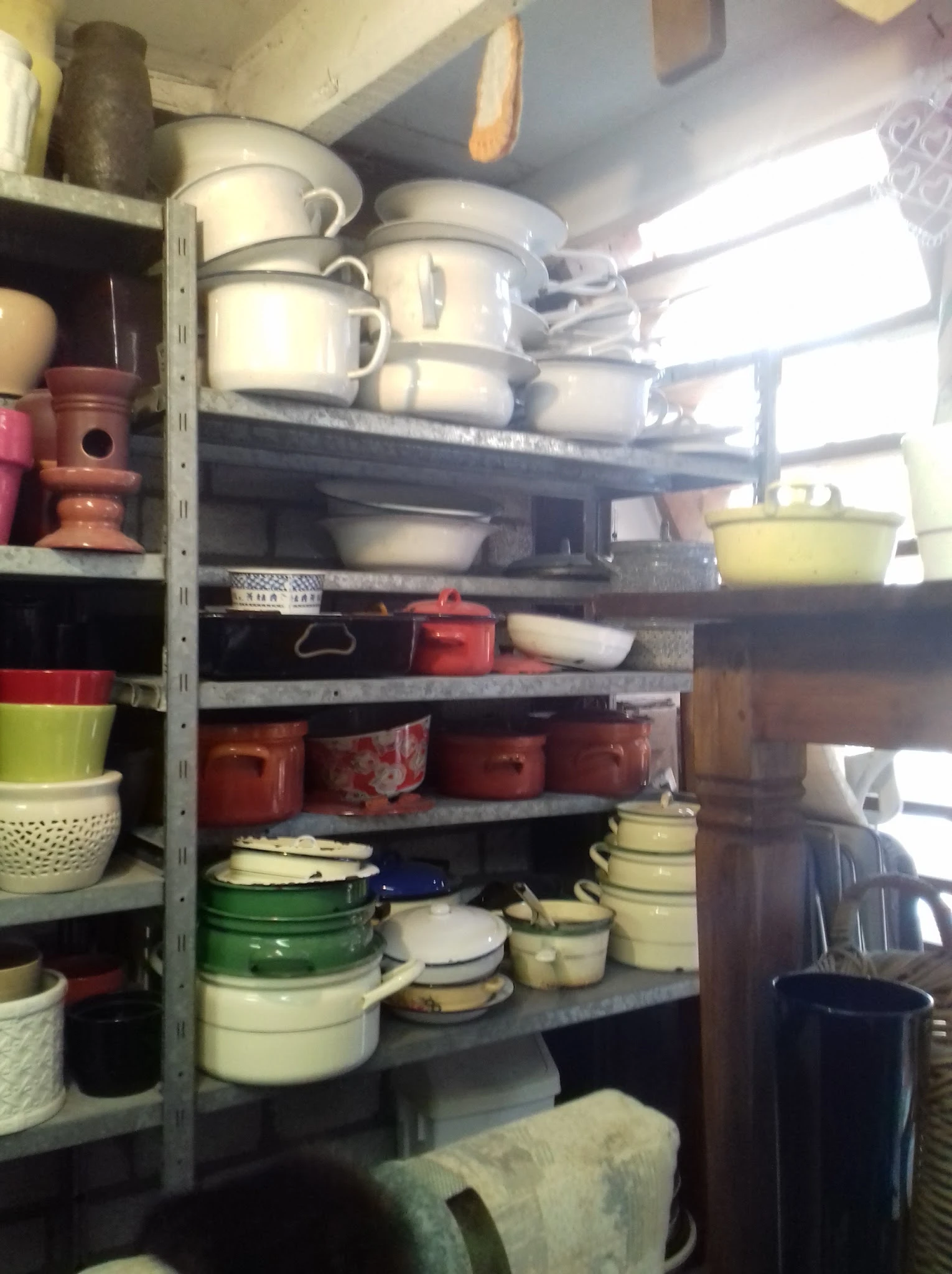 Stellingen met diverse servies- en kookgerei in verschillende kleuren