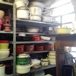 Stellingen met diverse servies- en kookgerei in verschillende kleuren