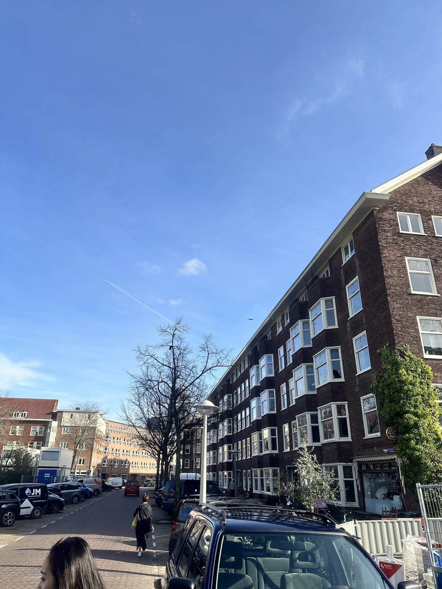 Straatgezicht met meerlagige bakstenen woningbouwgebouwen onder blauwe hemel