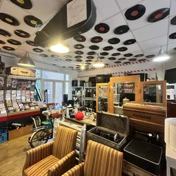 Winkelvloer van kringloopwinkel met meubels, rekken en vintage artikelen onder plafond met vinyl records