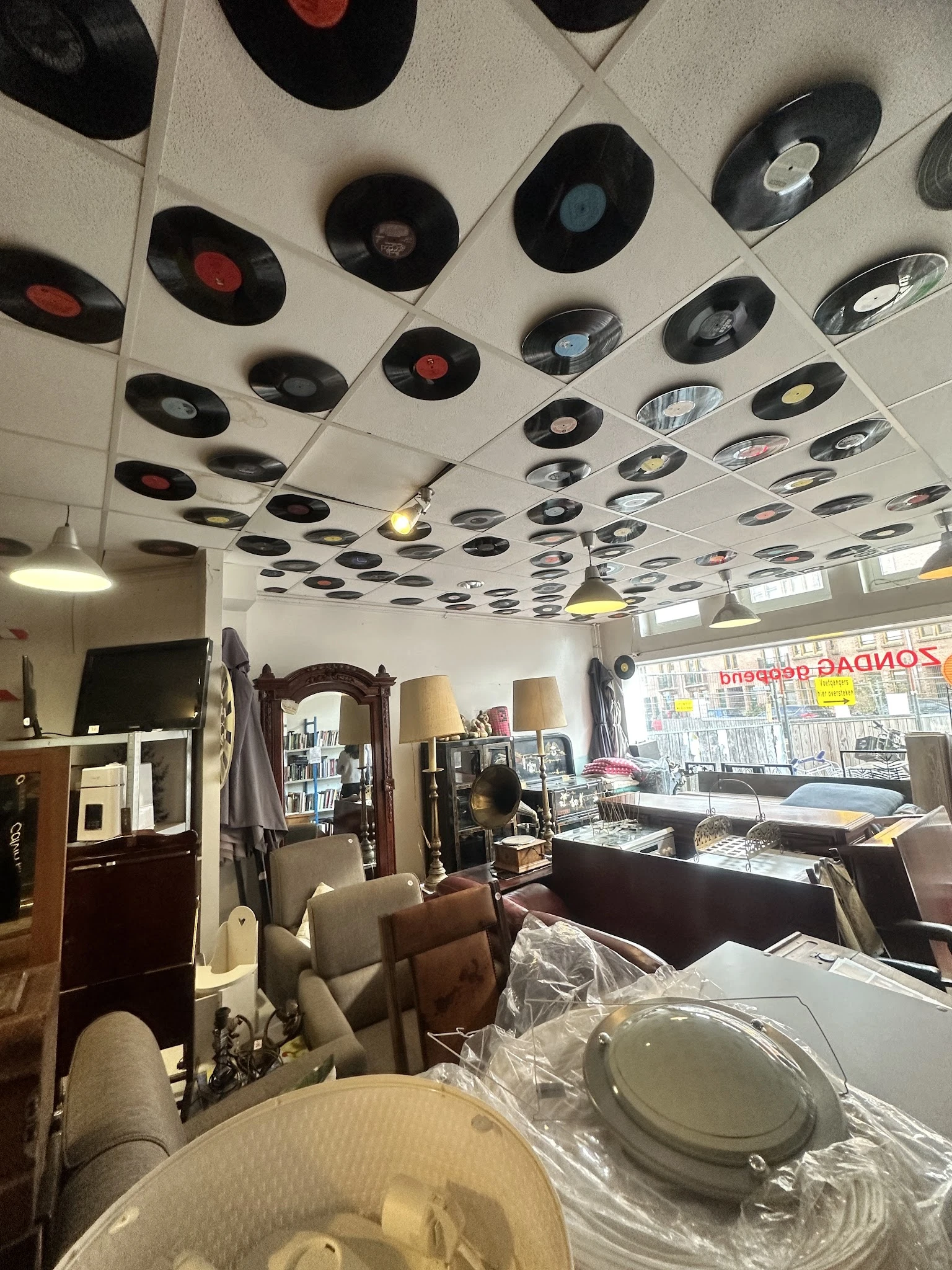 Winkelvloer met plafond versierd met oude vinyl platen, meubels en huishoudartikelen