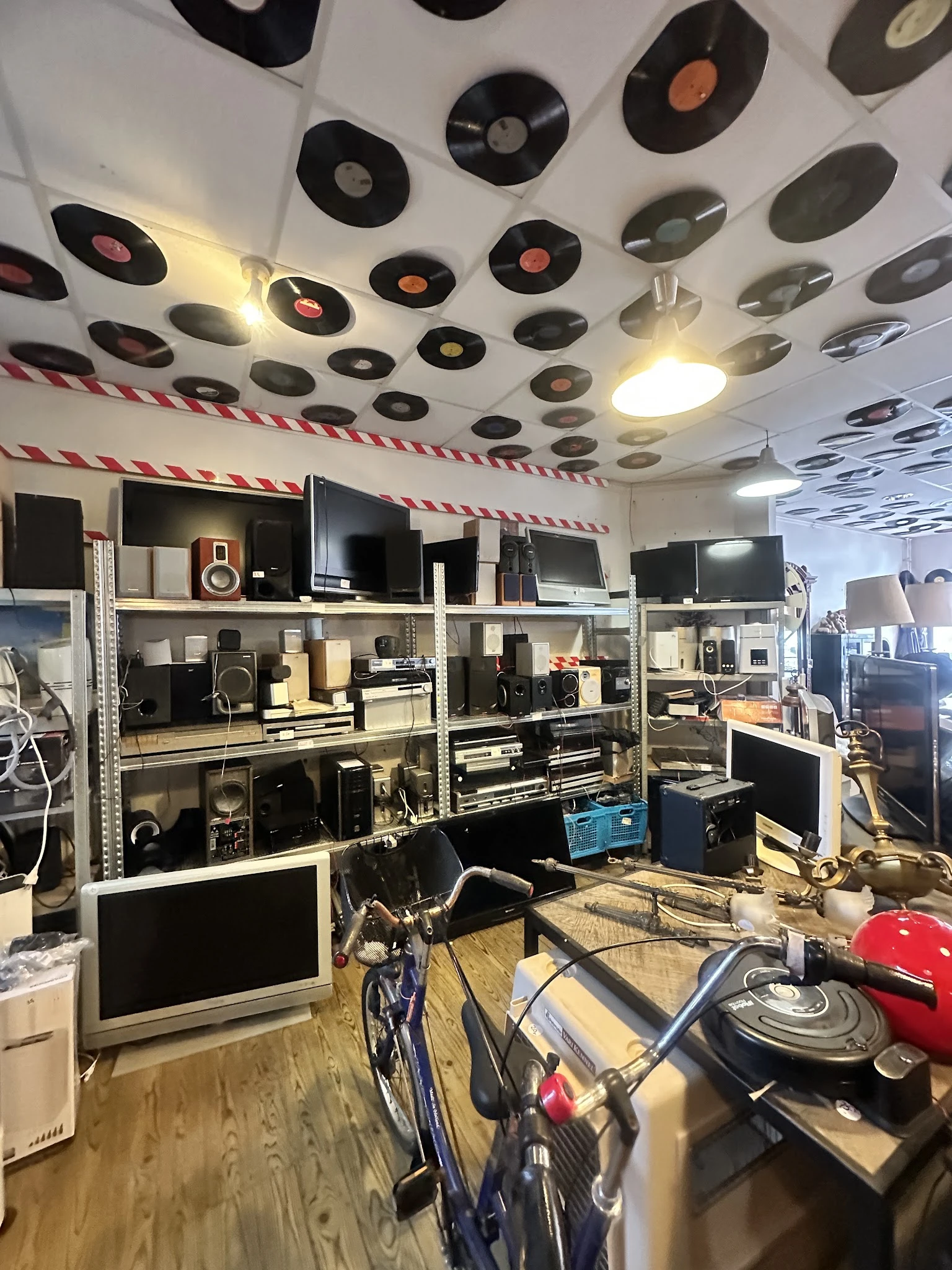 Stellingen vol met elektronica en audioapparatuur zoals speakers, monitors, versterkers en andere elektronische apparaten in 