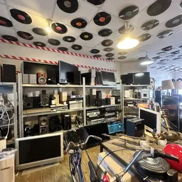 Stellingen vol met elektronica en audioapparatuur zoals speakers, monitors, versterkers en andere elektronische apparaten in 