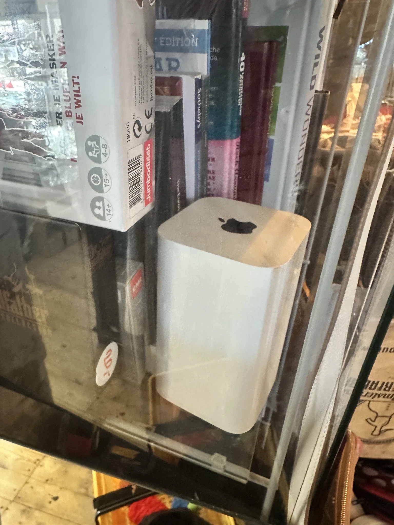 Witte Mac Mini computer met houten bovenkant in winkelstelling tussen andere artikelen