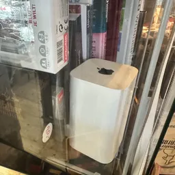 Witte Mac Mini computer met houten bovenkant in winkelstelling tussen andere artikelen