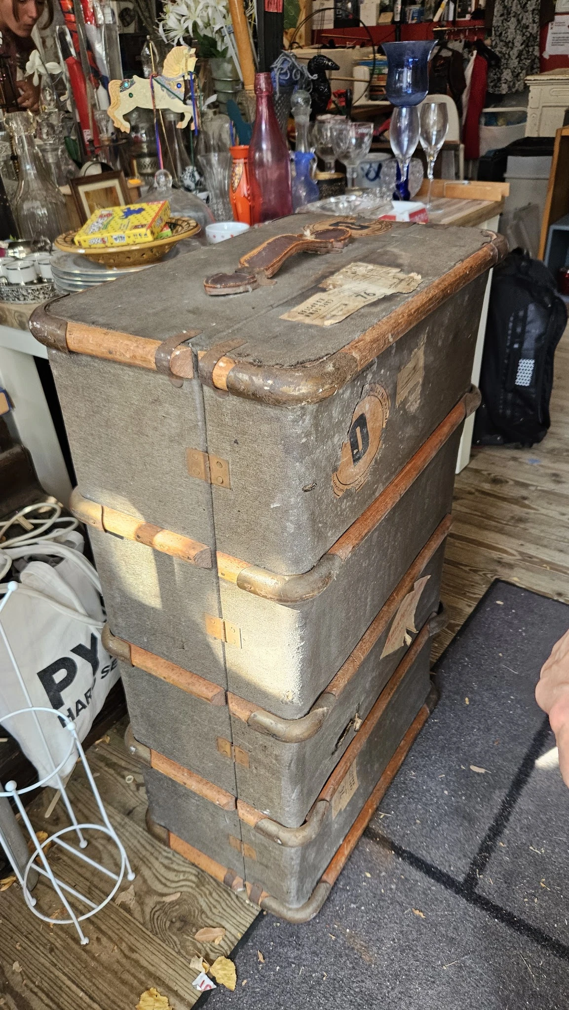 Oude vintage koffer of reiskoffer met leerlabels en koperen hoeken, gestapeld op houten onderstel