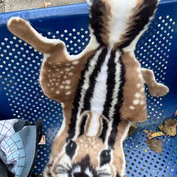 Close-up van een tweedehands dierenhuid of bont met bruine, witte en zwarte vlekkige patronen