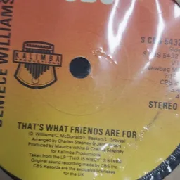 Close-up van een vinyl LP-hoes met gele en oranje kleurverloop, gedeeltelijk in plastic verpakt