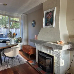 Woonkamerinterieur met open haard, zithoek en uitzicht op terras met decoratieve accessoires