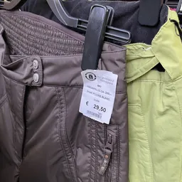 Prijskaartje van €29,50 aan een bruine ski-jas in een kringloopwinkel