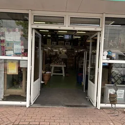 Entreepui van kringloopwinkel met openstaande deuren en uitzicht op winkelinterieur