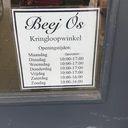 Openingstijden van Beej Ós Kringloopwinkel op een wit bord