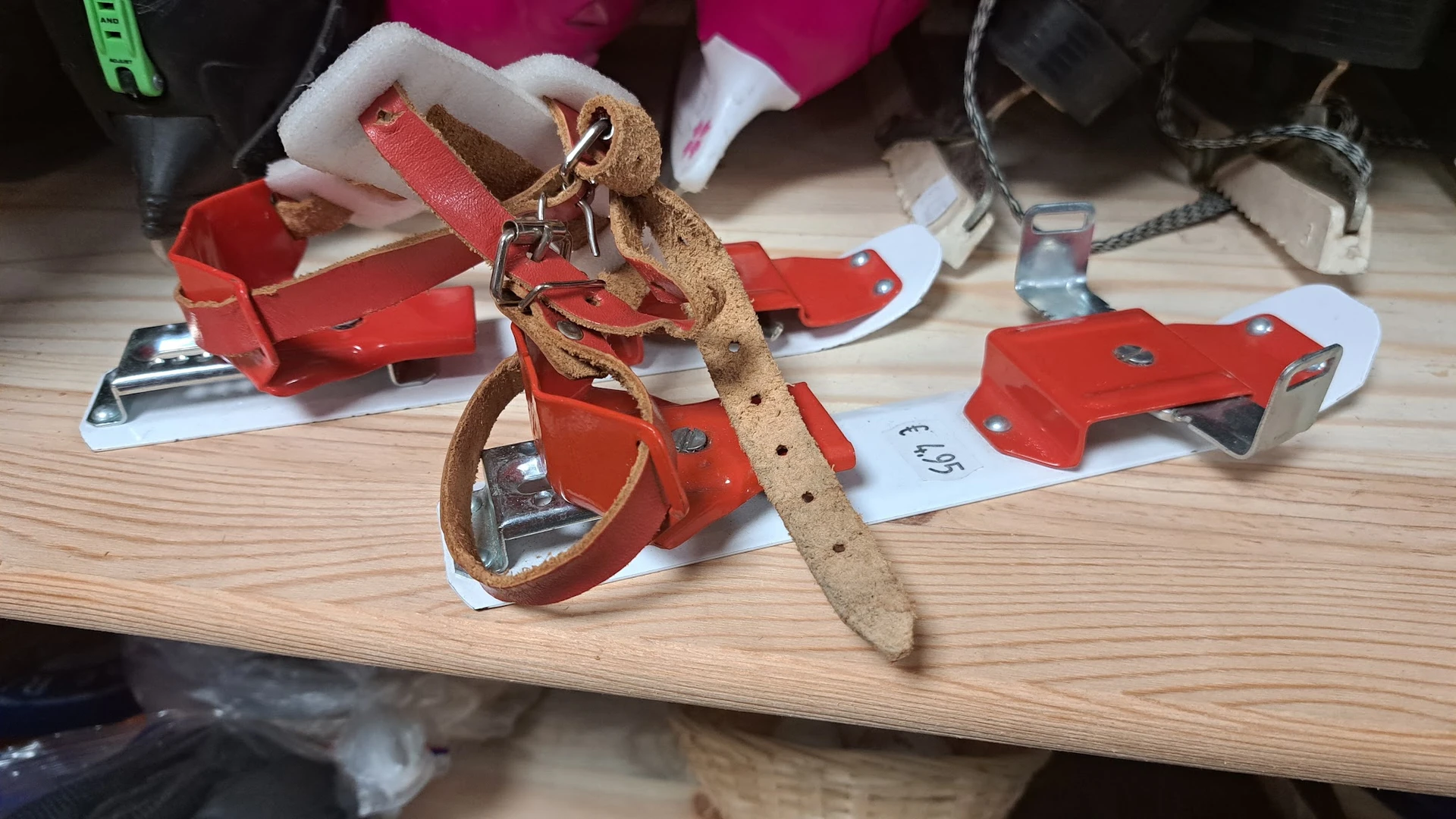 Close-up van een tweedehands leren riem met gesp en rode verpakkingslabels op houten tafel
