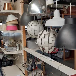 Diverse hangende lampen en lampenkappen in verschillende stijlen en kleuren op display