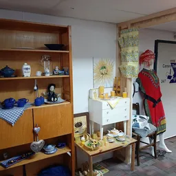 Winkelvloer met houten vitrinekasten, vintage meubels en diverse huishoudelijke spullen uitgestald