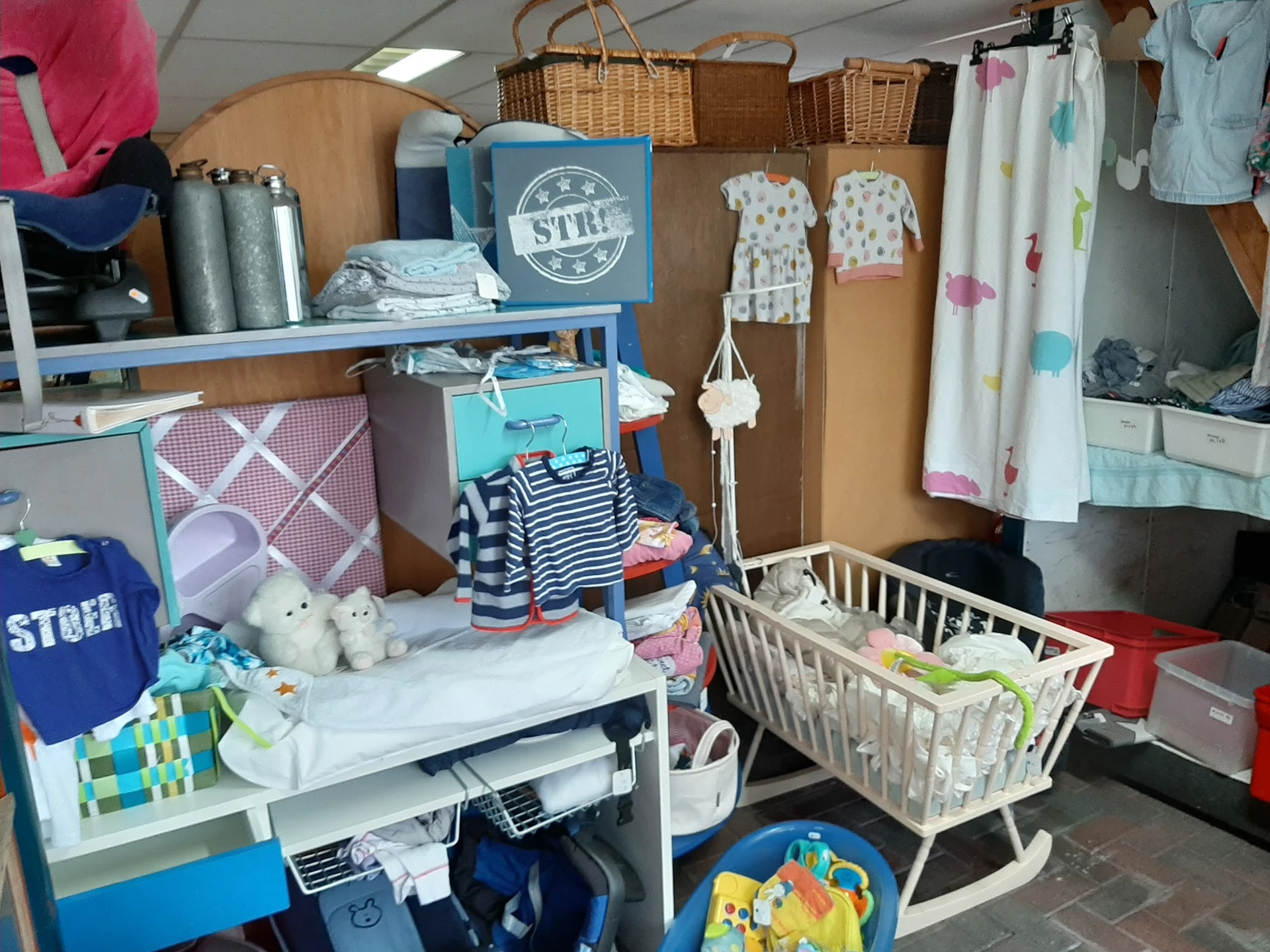 Babykamer spullen en kinderaccessoires: ledikantje, verschoontafel, speelgoed en textiel op stellingen
