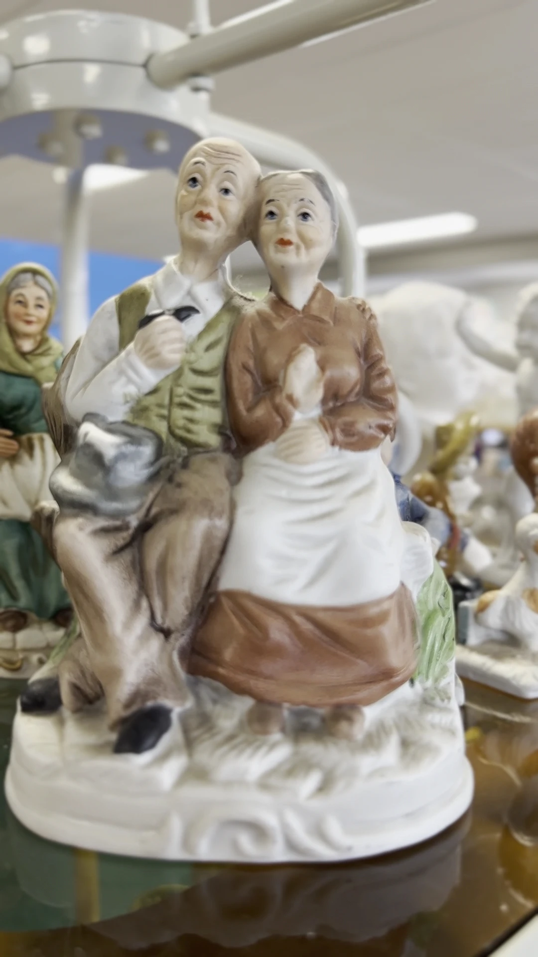 Porseleinbeeldje van een vrouw in bruine en witte kledij met hoofddoek