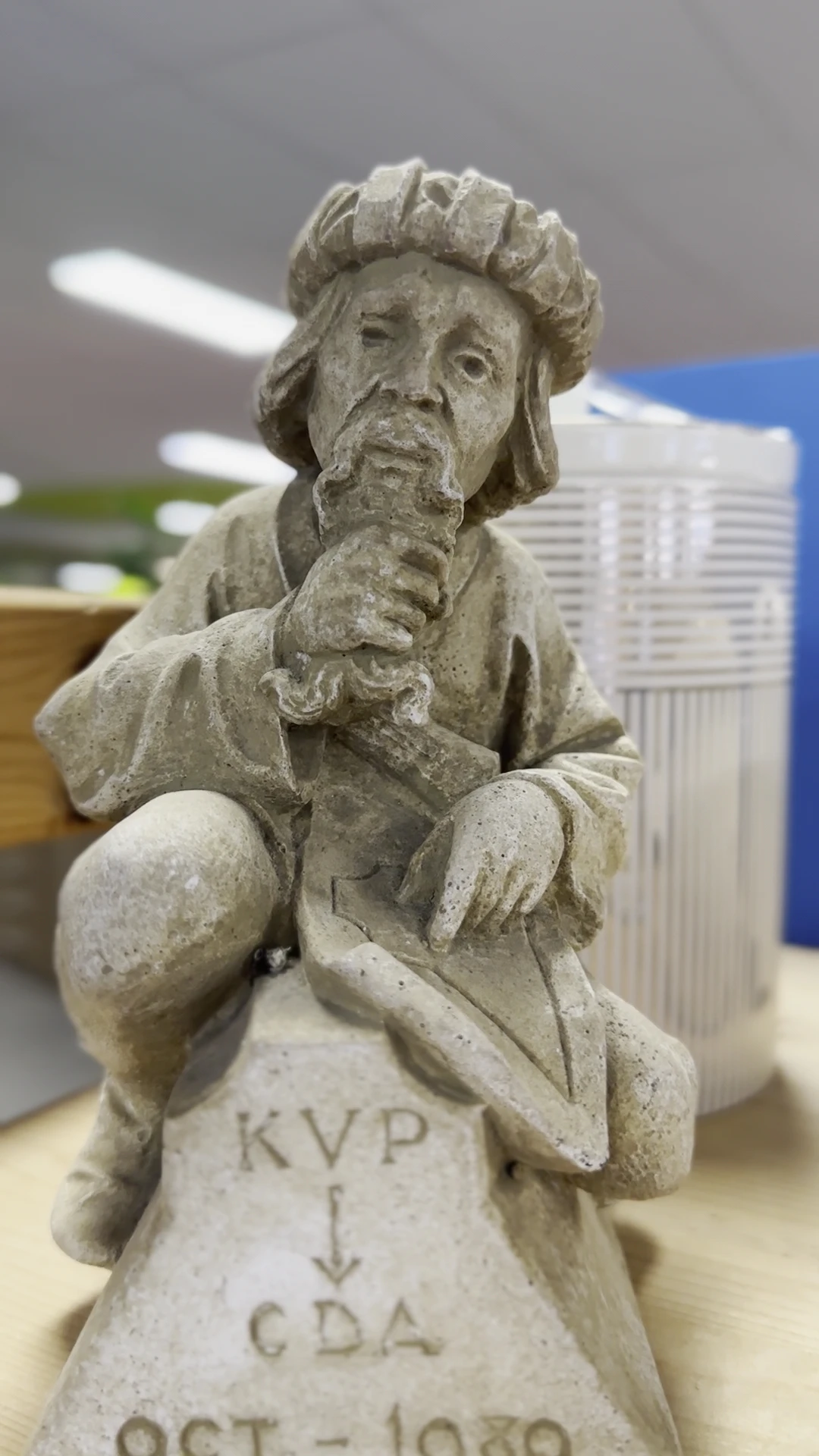 Close-up van een stenen beeld van een zittend figuur met gedetailleerde gezichtsuitdrukking
