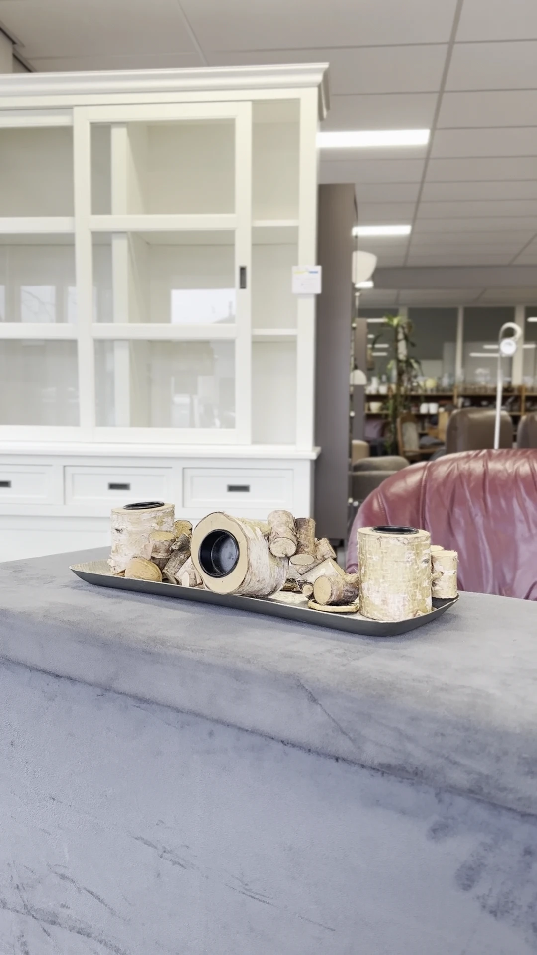 Decoratieve tafelschikking met witte stenen objecten en vazen op zwarte plateau