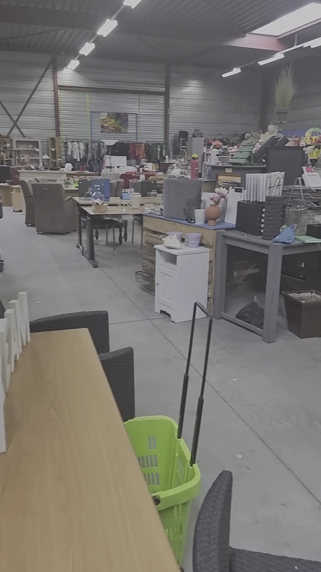 Winkelvloer met tafels, stoelen, kasten en huishoudapparatuur in een kringloopwinkel