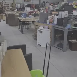 Winkelvloer met tafels, stoelen, kasten en huishoudapparatuur in een kringloopwinkel