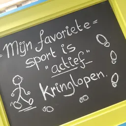 Schoolbord met krijt waarop 'Mijn favoriete sport is adeltje kringlopen' staat geschreven