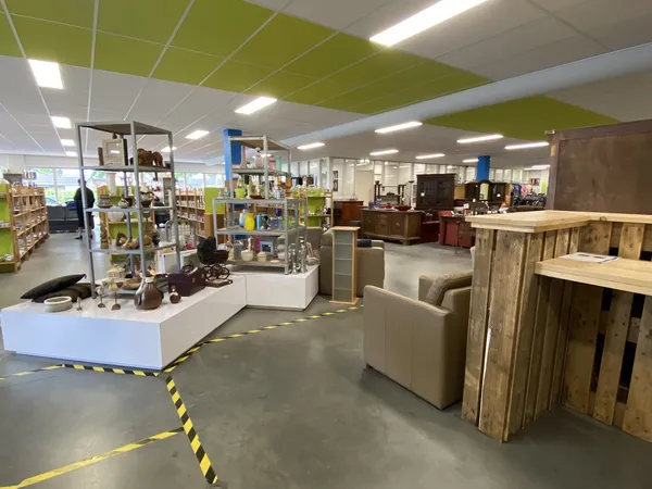 Winkelvloer met stellingen, toonbanken en meubelstukken in een kringloopwinkel