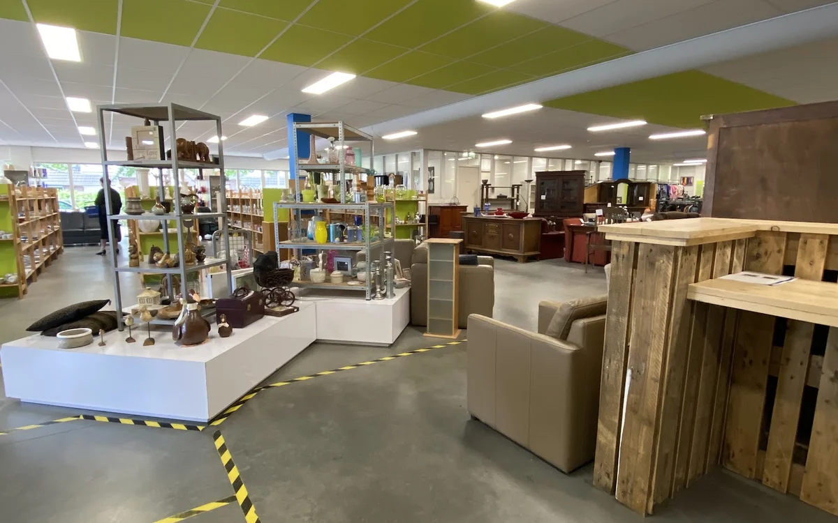 Winkelvloer met stellingen, toonbanken en meubelstukken in een kringloopwinkel