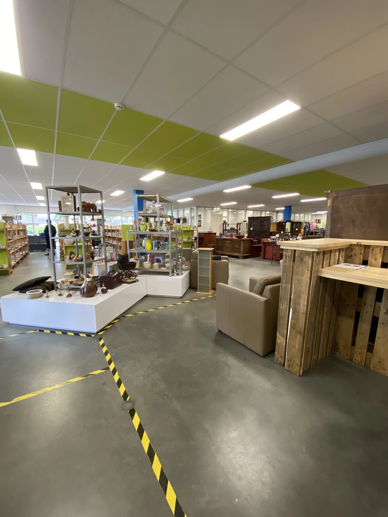 Winkelvloer met stellingen, toonbanken en meubelstukken in een kringloopwinkel