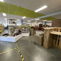 Winkelvloer met stellingen, toonbanken en meubelstukken in een kringloopwinkel
