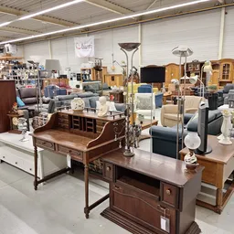 Winkelinterieur met meubelen: tafels, stoelen, kasten en overige huisraad uitgestald in een groot magazijnachtig pand