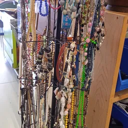 Rekken met sieraden, kettingen en armbanden in diverse kleuren en materialen