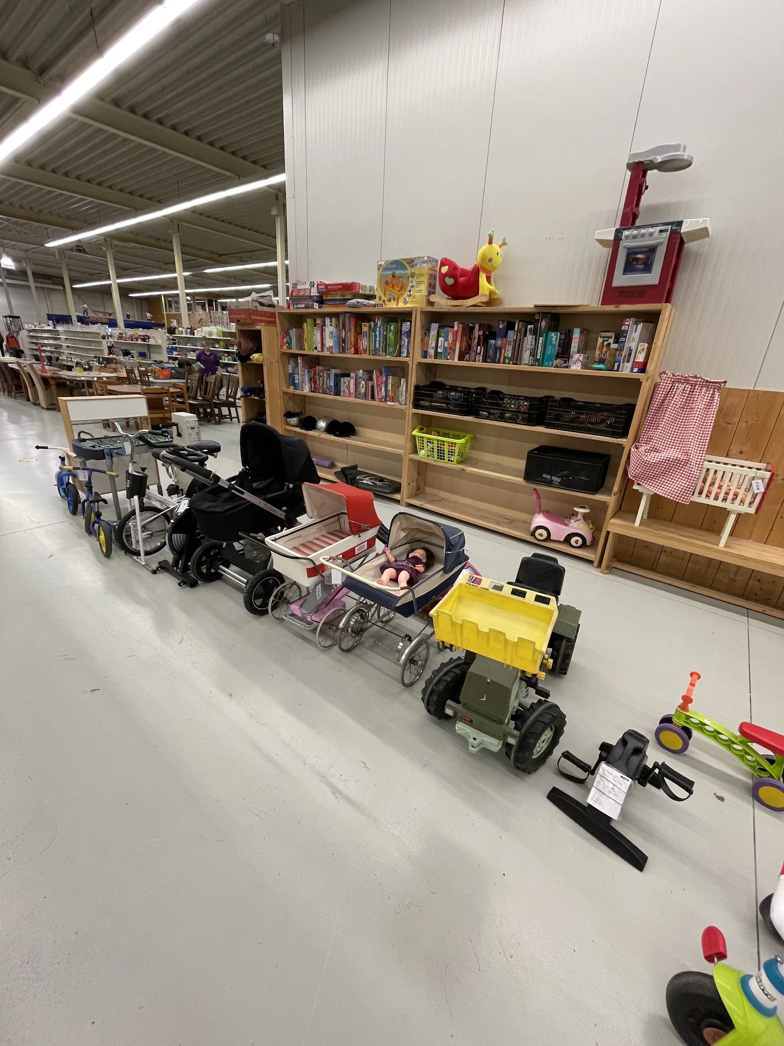 Diverse kinderwagens, buggy's en speelgoedvoertuigen uitgestald in de winkel