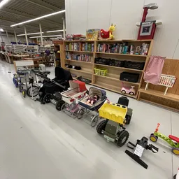 Diverse kinderwagens, buggy's en speelgoedvoertuigen uitgestald in de winkel