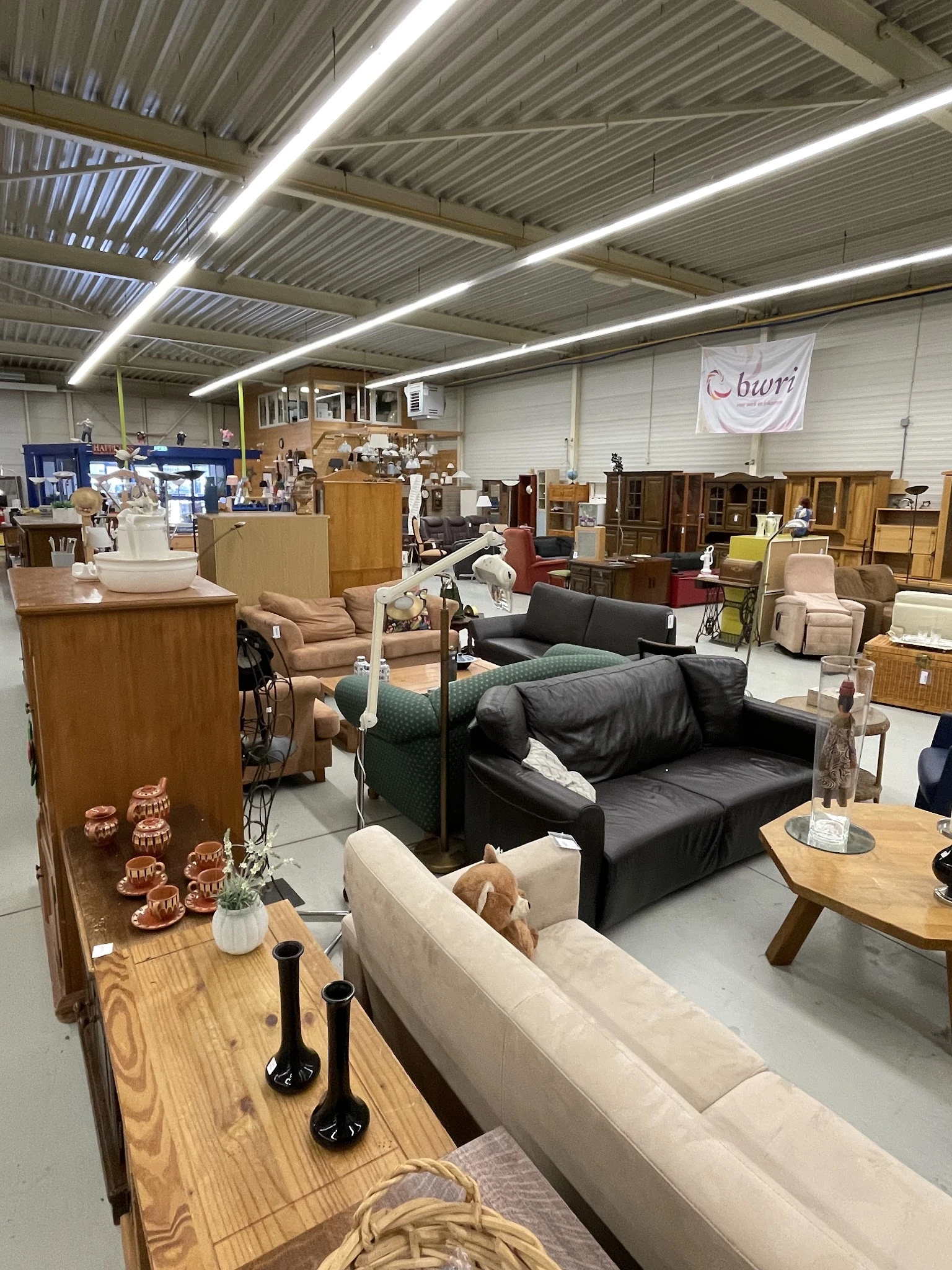 Winkelvloer met diverse meubels: banken, stoelen, tafels en houten kasten