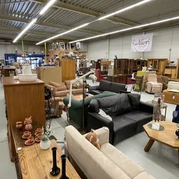 Winkelvloer met diverse meubels: banken, stoelen, tafels en houten kasten