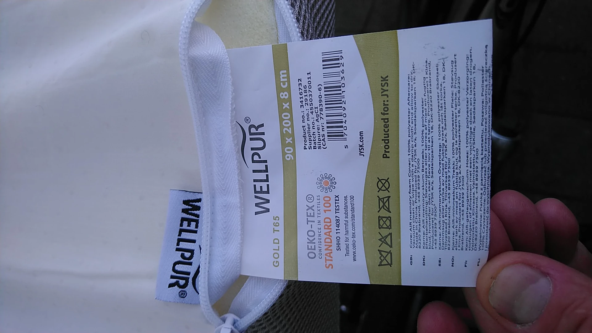 Close-up van een witte sokkel met product- en verzorginginformatie