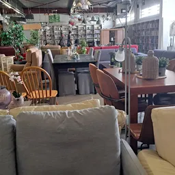 Winkelvloer met diverse meubels: stoelen, tafels, kasten en boekenkasten; industrieel interieur met veel aantal tweedehands a