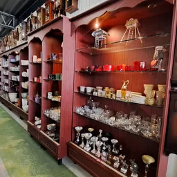 Rode houten stellingkasten met kaarsen, wierookhouders en decoratieve items uitgestald