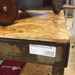 Houten artefact met wielen en prijskaartje van €150,00 in de winkel