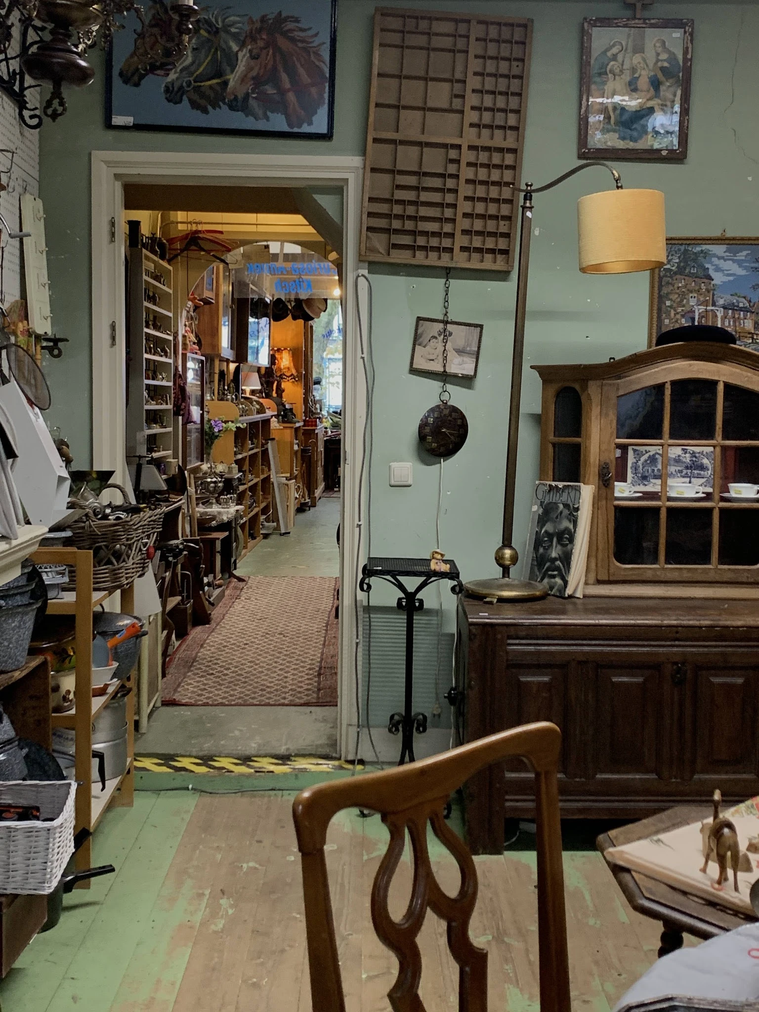Binnenaanzicht van kringloopwinkel met stellingen, meubels en diverse tweedehands spullen langs de wanden