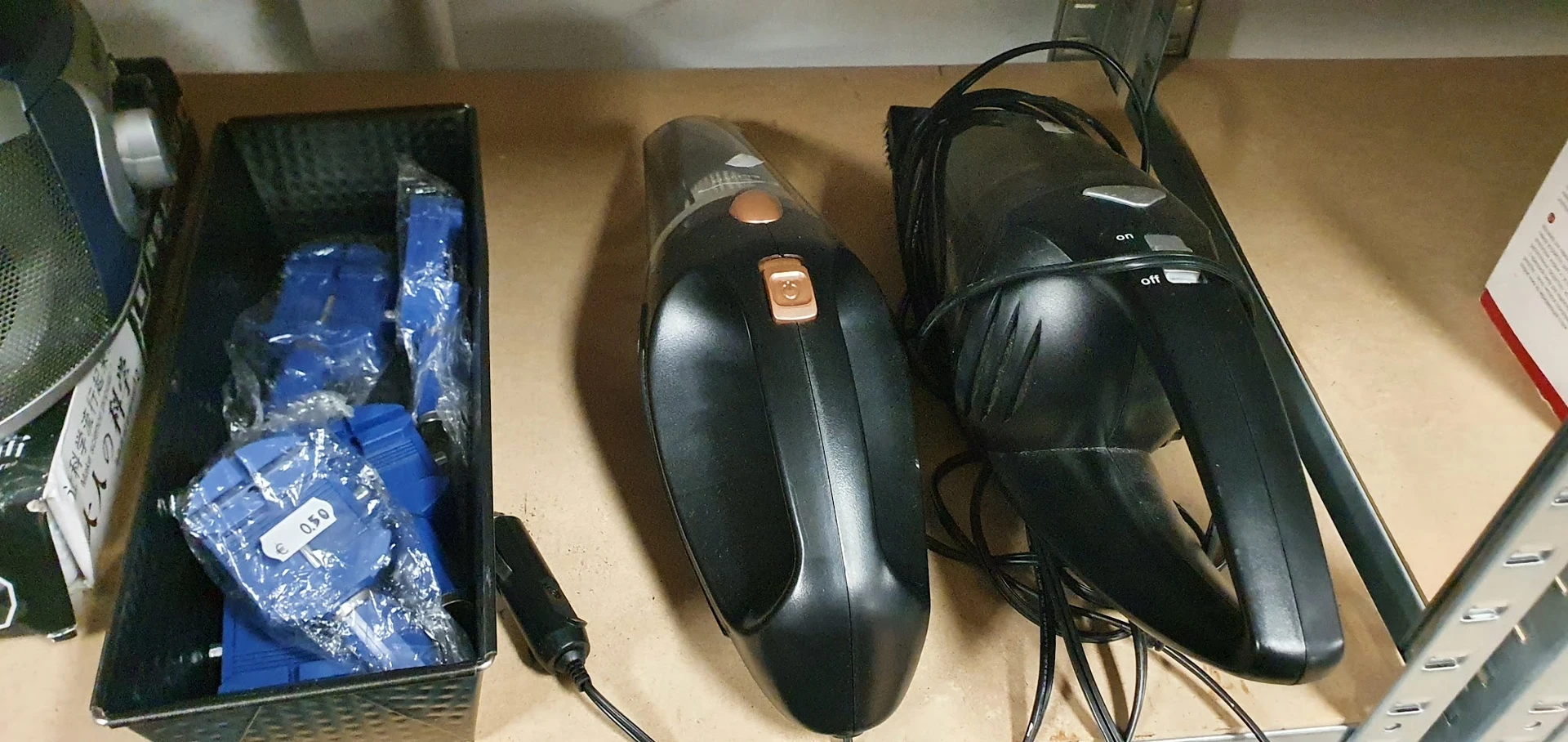 Drie zwarte computermuizen met kabels op een tafel, één met oranje details