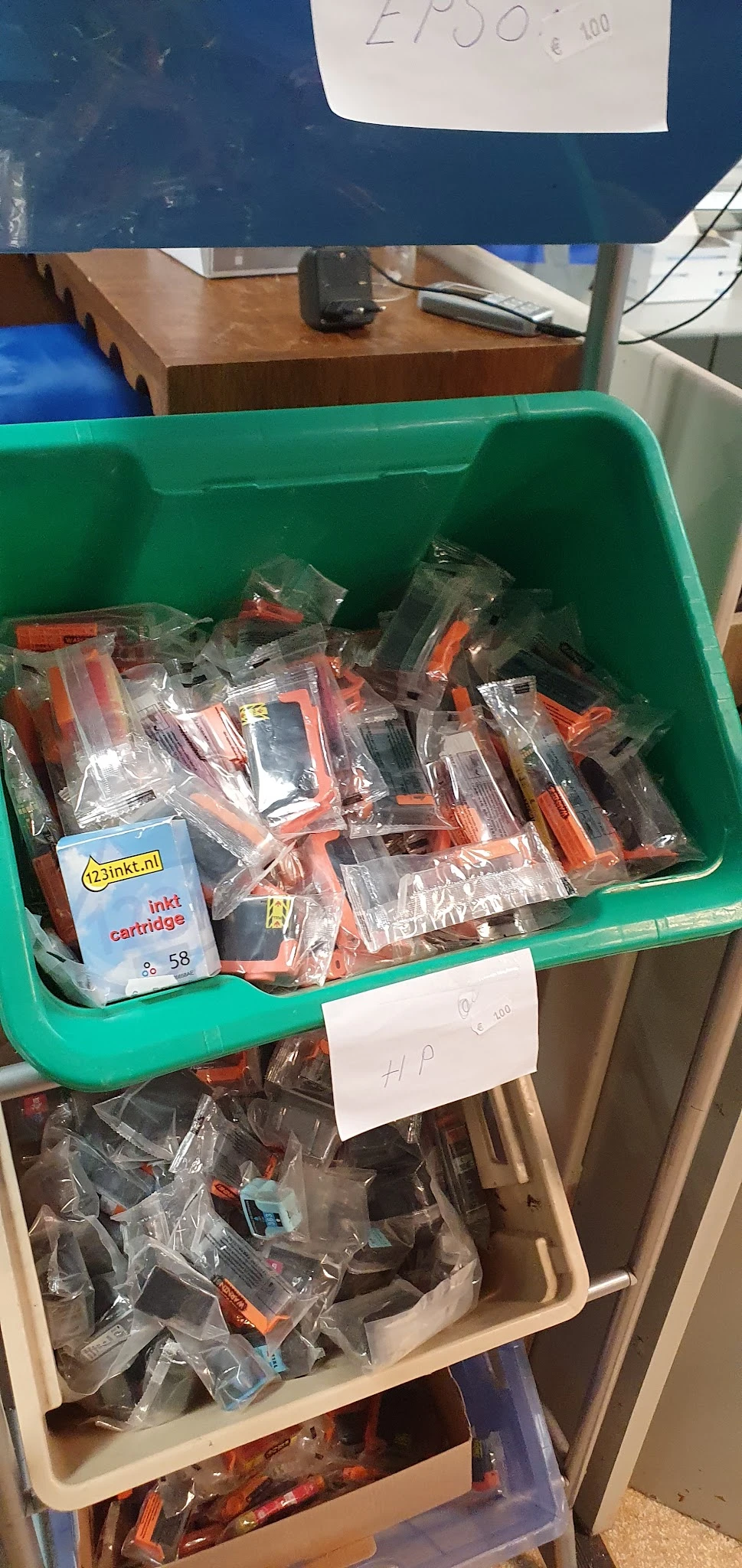 Groene krat met verpakte inktcartridges en printeronderdelen