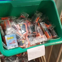 Groene krat met verpakte inktcartridges en printeronderdelen
